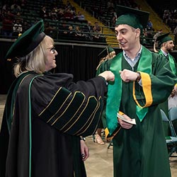 photo of a graduate and president edwards at commencement