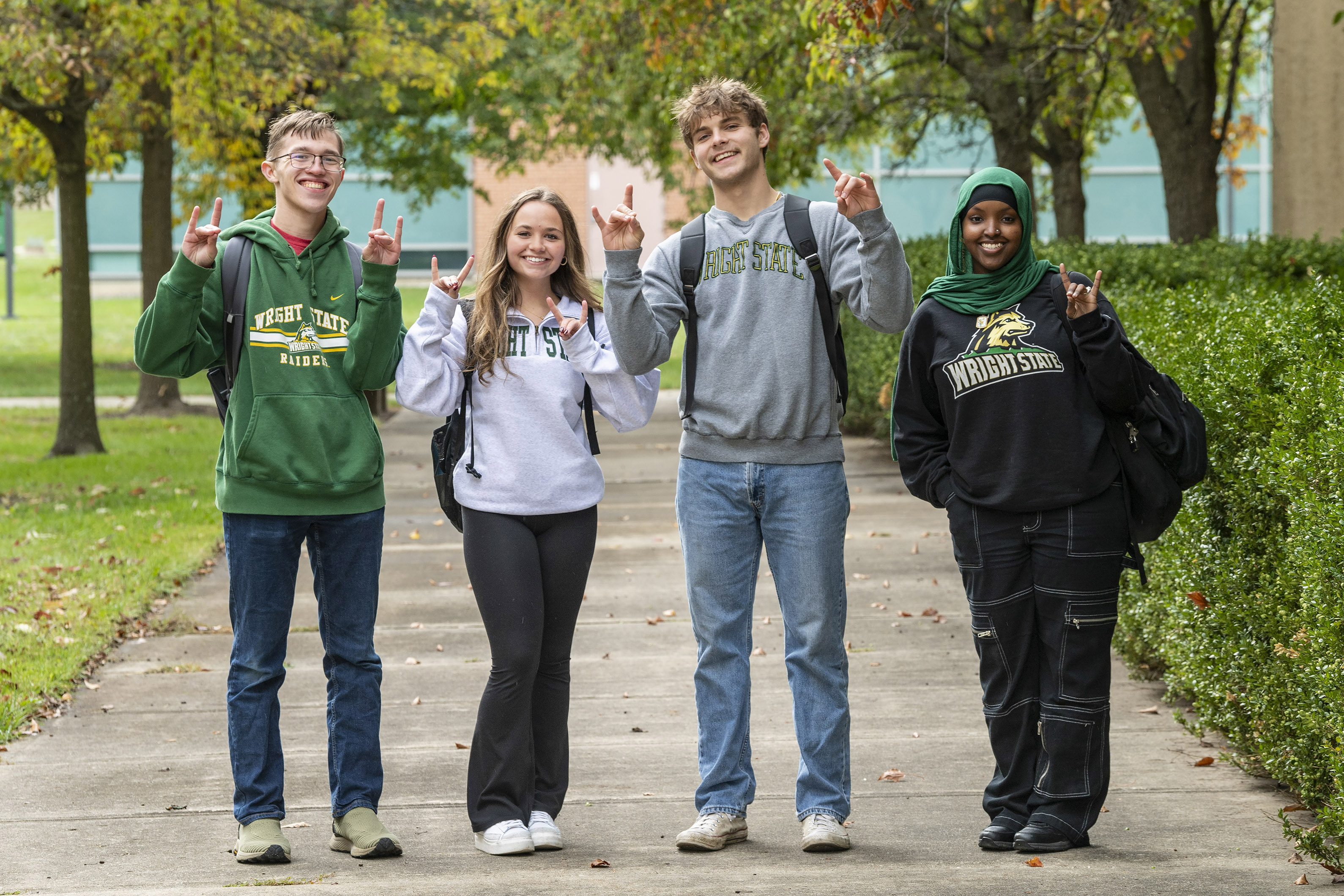 photo of four smiling wright state students standing outside on campus