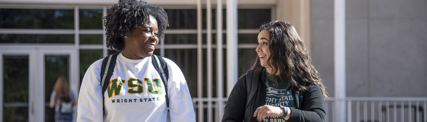 photo of two students walking together outside on campus