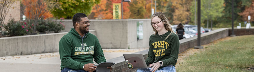 photo of students sitting outside on campus 