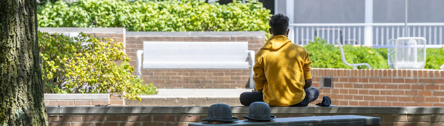 photo of a student sitting outside on campus