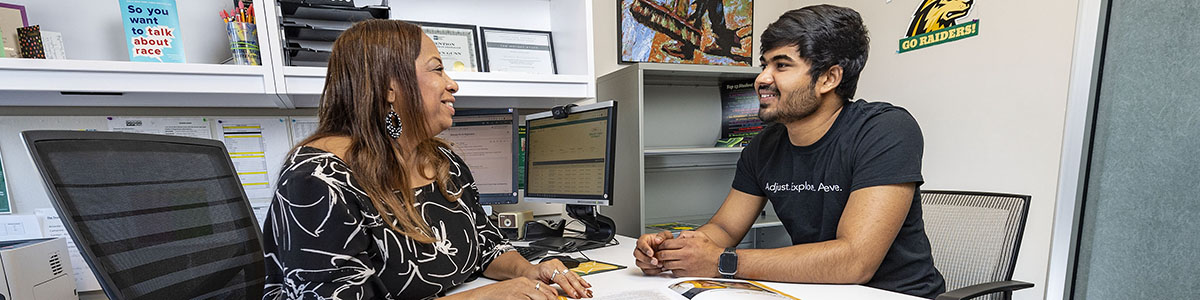 photo of a student and success coach meeting in an office