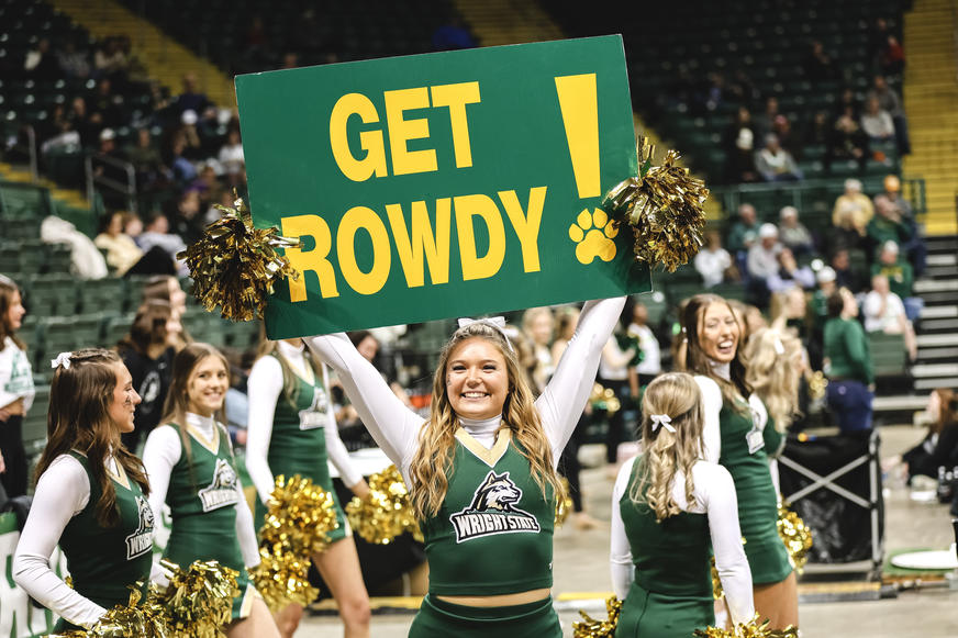 Cheerleader pumping up crowd with Get Rowdy Sign