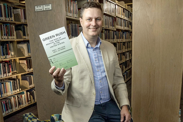 Lee Hannah holds his book